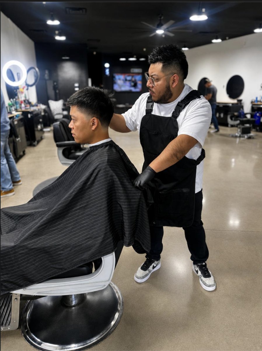 Barber finishing a mid fade for a client at To the Nines Barbershop in Tempe