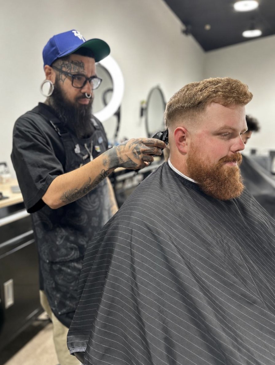 Barber blending a skin fade for a client with a red beard in Tempe, AZ