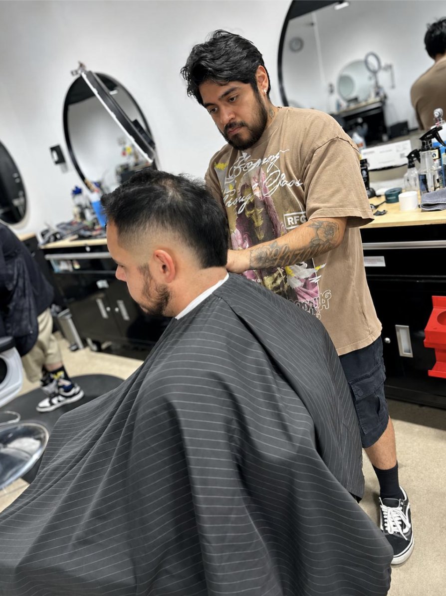 Barber cleaning up a client's fade at To the Nines Barbershop